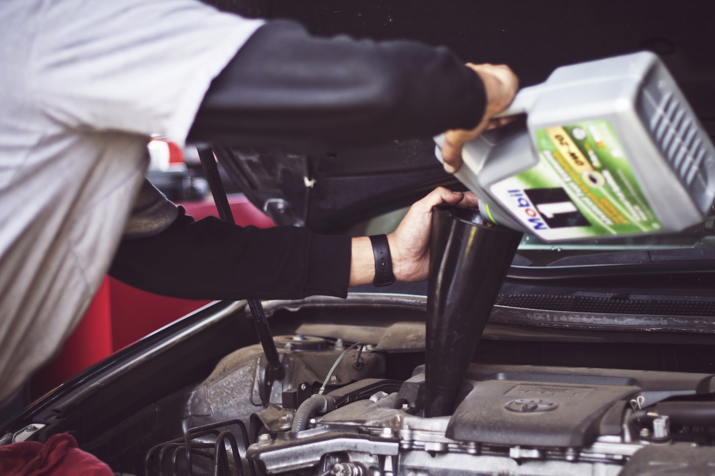 Mechanic working under a vehicle hood